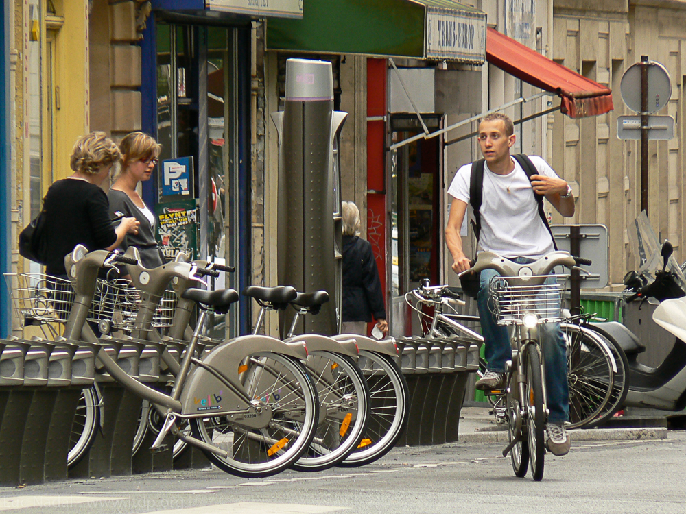 User leaving after unlocking a cycle from an automated docking system in Paris, France.